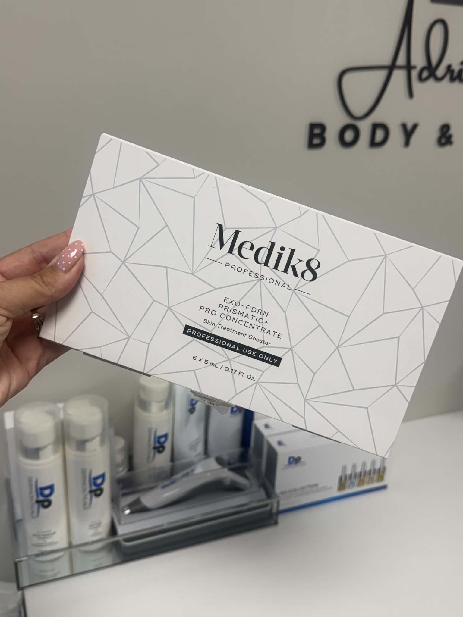 Adriana holding the Medik8 Exo-PDRN Prismatic+ Pro Concentrate in the studio